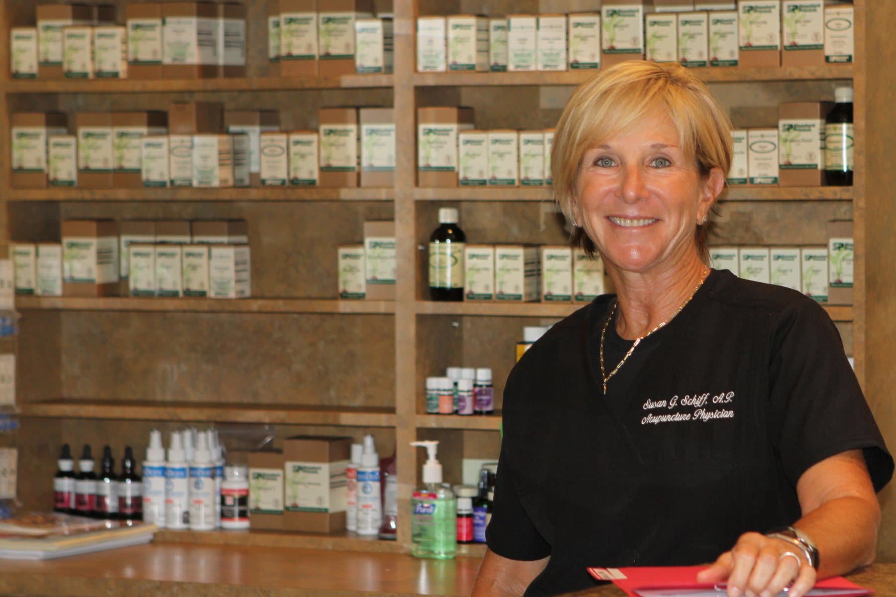 Dr. Susan Schiff smiling in front of shelves of herbal and nutritional supplements