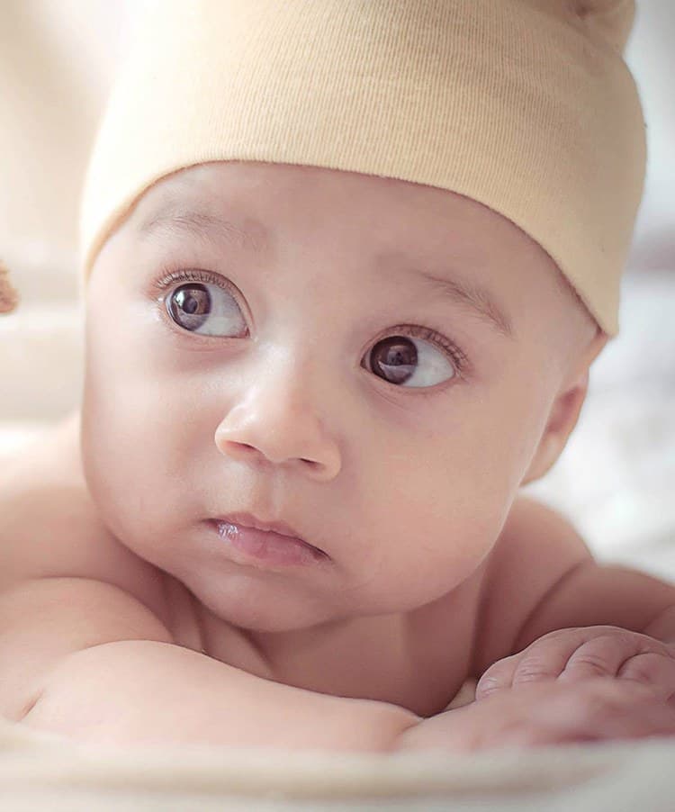A newborn in a knit cap looking to the side